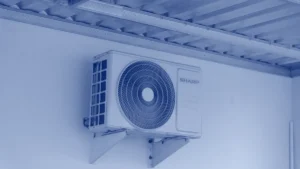 Unidad de aire acondicionado tipo split instalada junto al techo de un local
