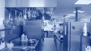 Cocina comercial con campana extractora sobre la línea de cocción