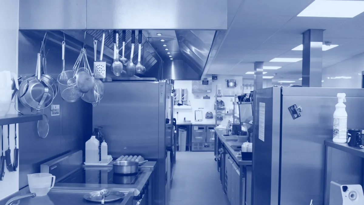Cocina comercial con campana extractora sobre la línea de cocción